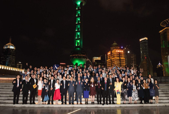 Celebration attendees stand in front of Shanghai city backdrop