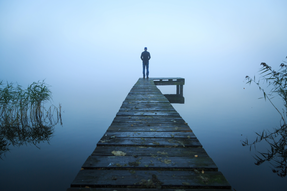 A man standing at the edge of a wooden pier