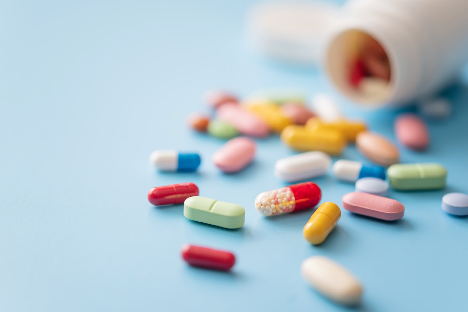 Colourful pills spilling from bottle